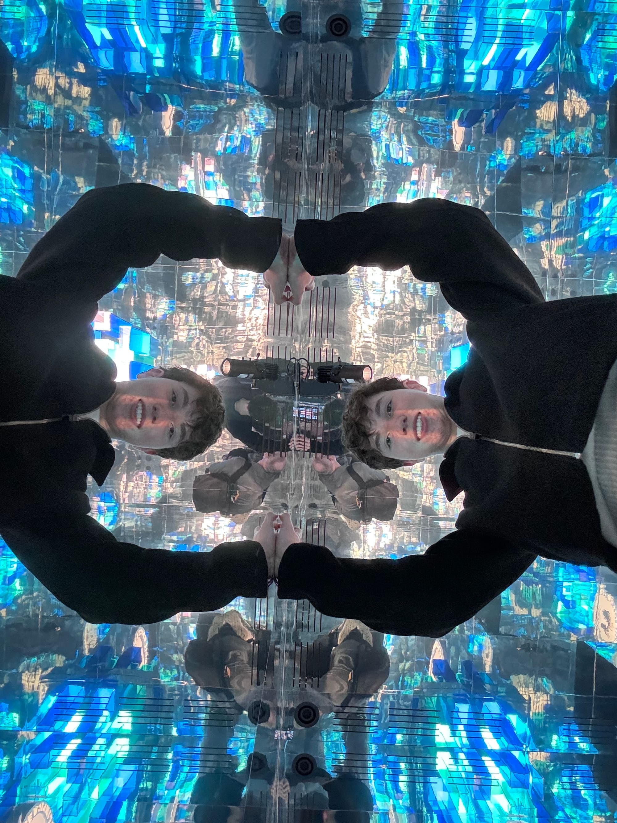 Louis-François Geoffrion reflected in an infinity mirror room lit in blue